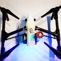 Top view of a drone with a drone parachute recovery system securely mounted to the airframe by a harness