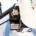 Closeup of drone parachute trigger system and mounting plate on the airframe of a drone