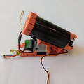 Side view of a drone parachute launcher on a mounting plate