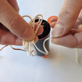 Demonstration of z-folding the shock cord of a drone parachute after packing the canopy in the canister