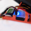 Side view of a drone parachute automatic trigger system connected to a drone parachute launcher
