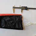 Caliper next to unpacked drone parachute in preparation for folding
