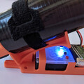 Side view of a disarmed automatic drone parachute trigger system and drone parachute launcher