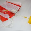 Unfolded parachute next to a parachute folding and rigging jig