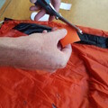 Demonstration of cutting a patch for a damaged parachute canopy