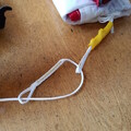 Closeup of folded drone parachute with a weight on top and the parachute bridle and shock cord