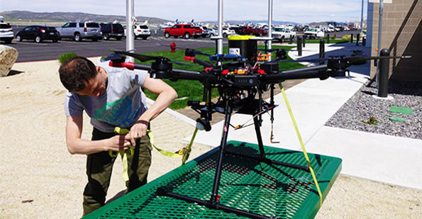 NIAS drone operator preparing drone with Peregrine UAV ballistic recovery system installed