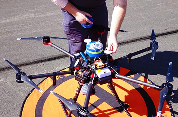NIAS drone operator securing Peregrine UAV ballistic recovery system onto drone